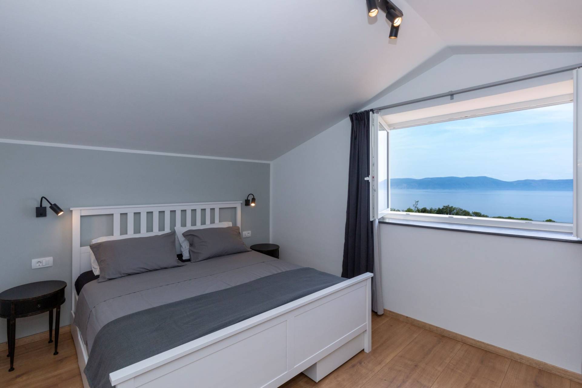 Bedroom with bed for two and a view from the window to the beautiful azure Adriatic sea