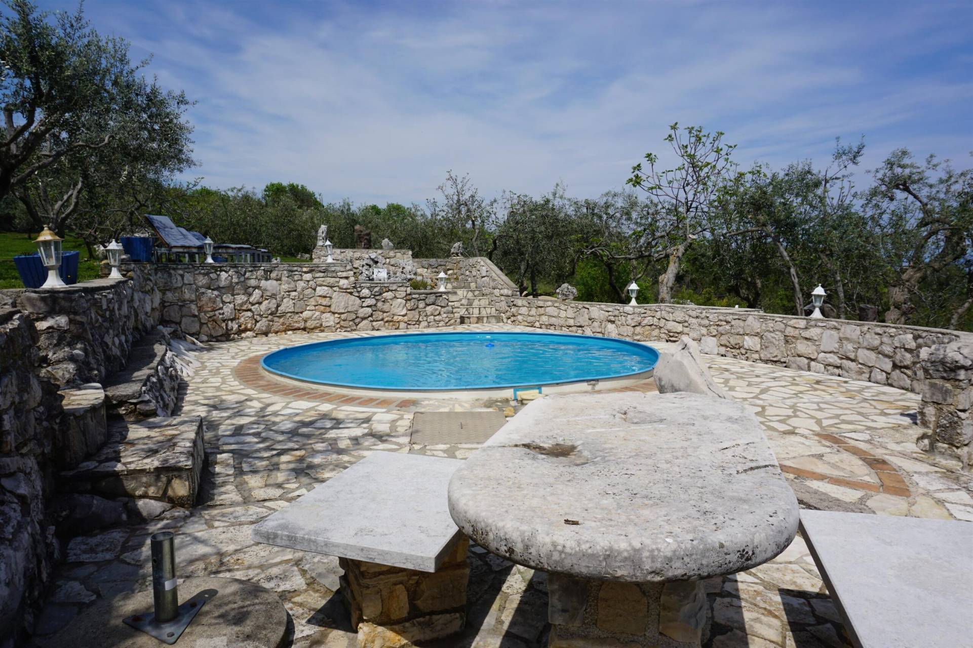 A view to the pool from stone table and stone benches