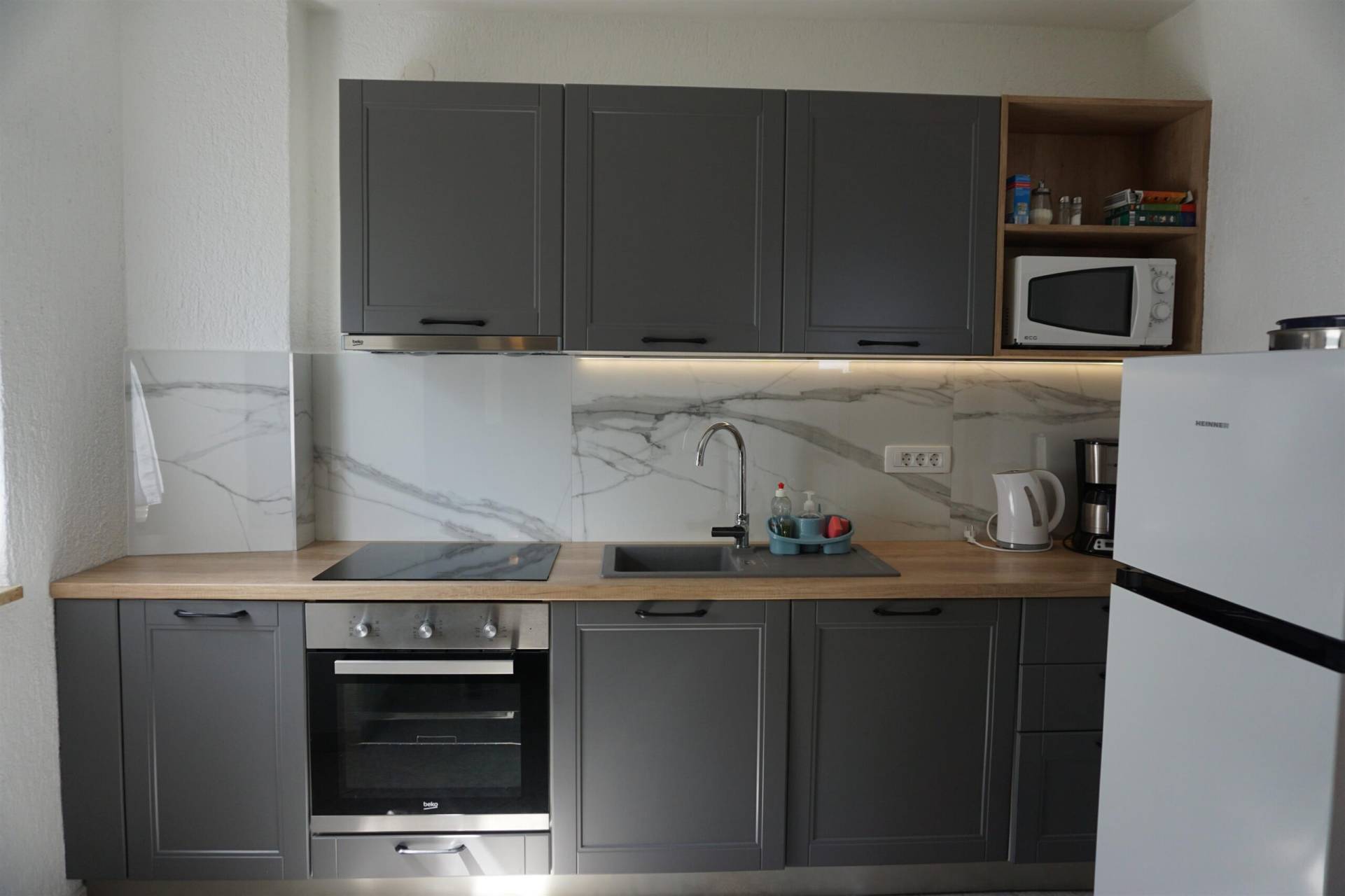 Modern kitchen with marbel tiles and gray kitchen elements