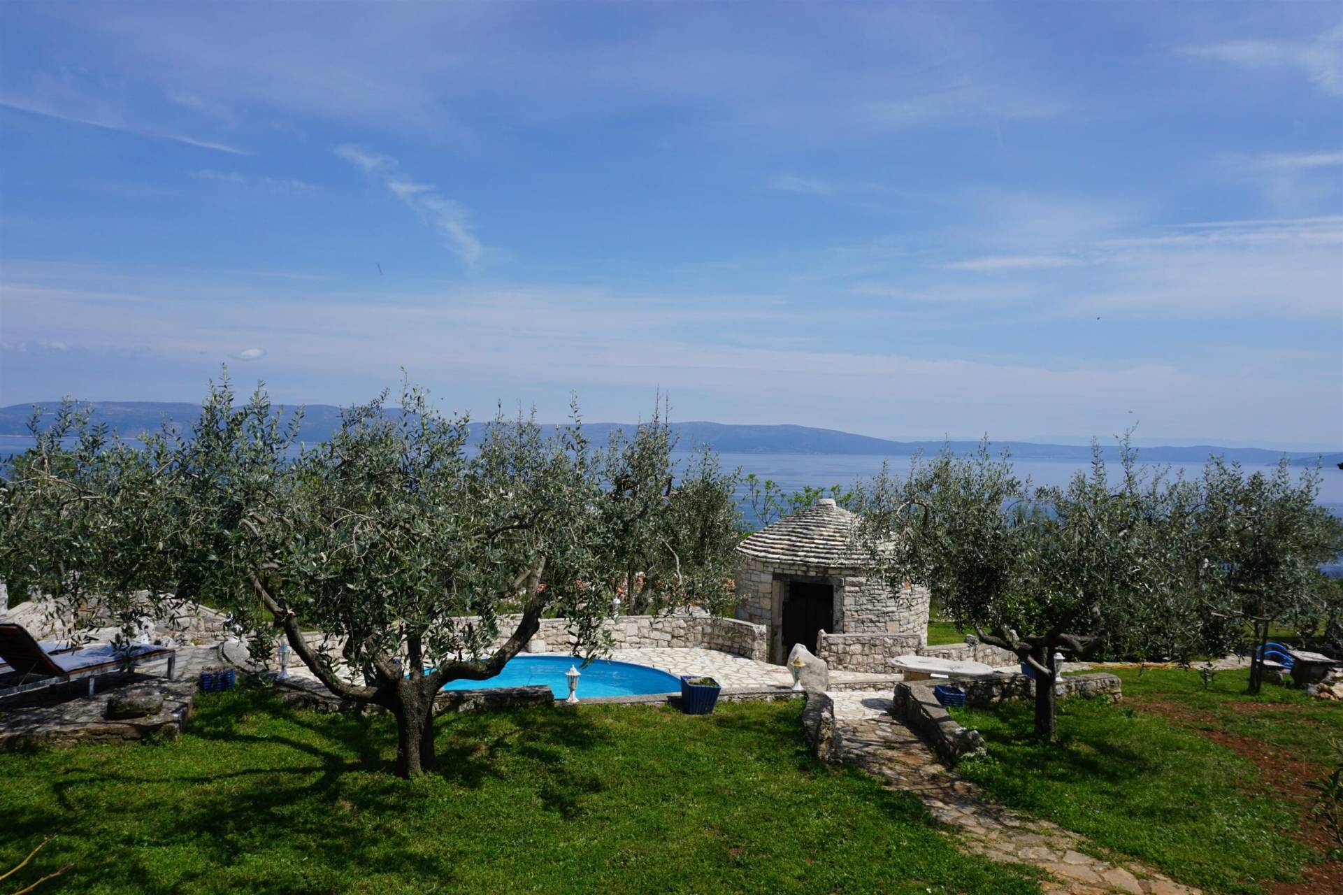 Beautiful view of the adriatic sea from the terace of the yard of the house along with olive trees and pool